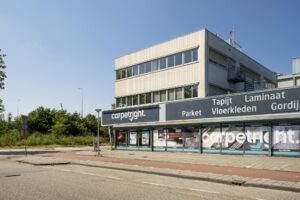 Vooraanzicht van het Carpetright-winkelpand aan de Anthony Fokkerweg met reclame voor vloerbedekking en gordijnen.
